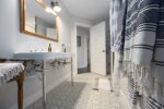 Full bathroom in the caretakers suite has a walk-in shower, separate tub, double vanity, and toilet closet